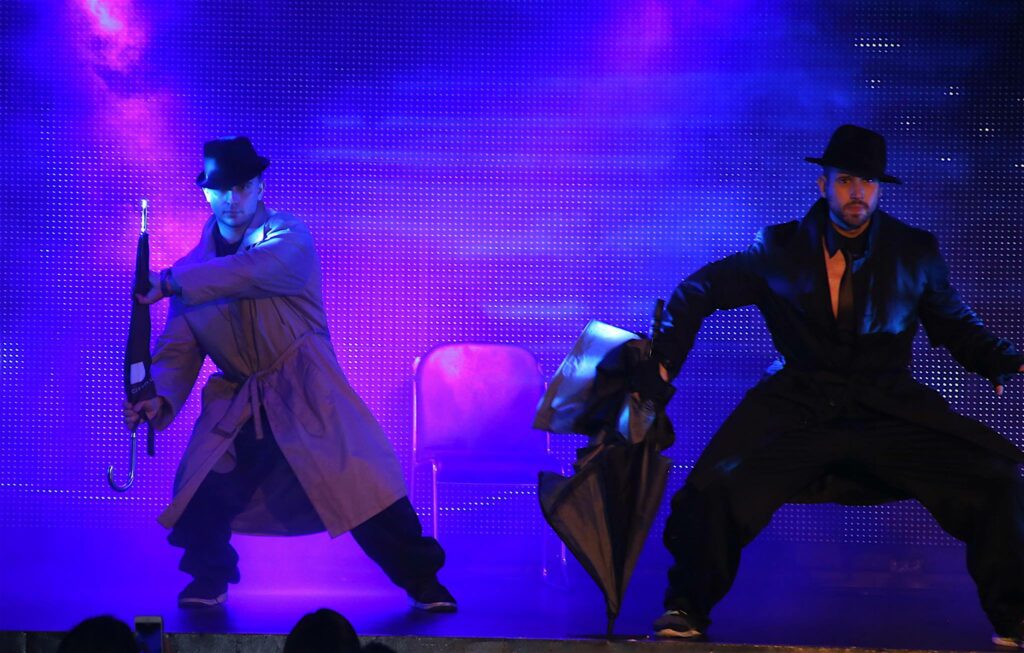 Two men in trenchcoats on the stage at Hunk-O-Mania