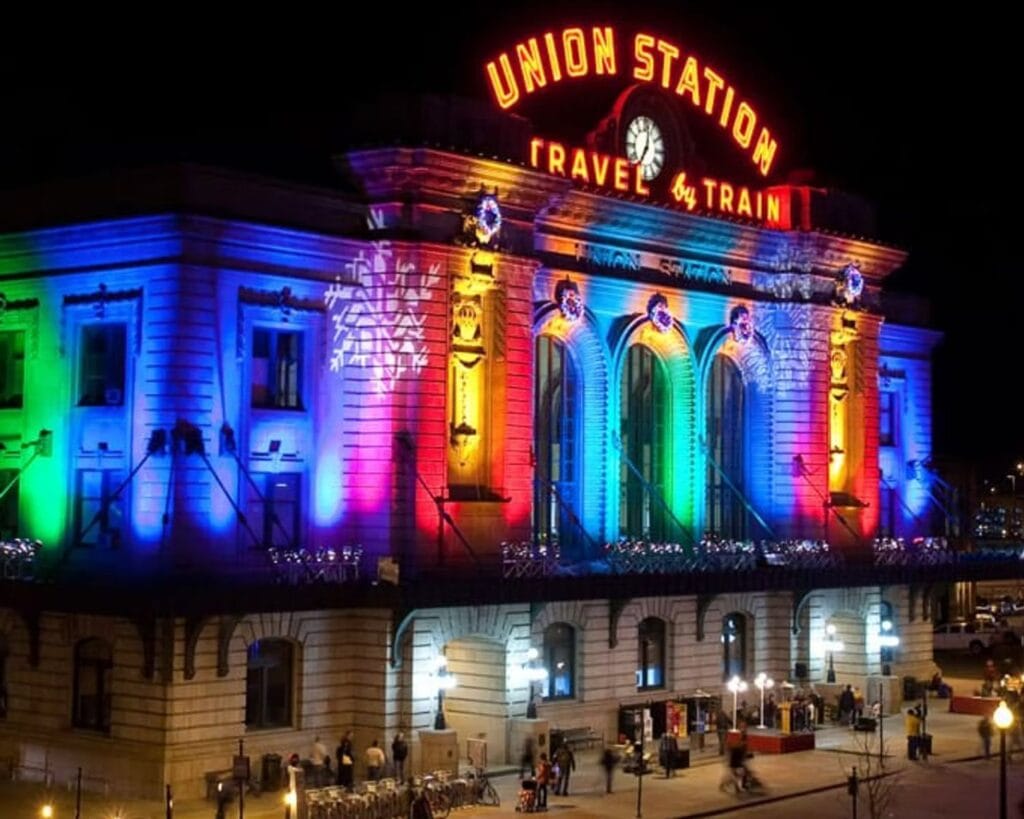 Denver Union Station lit up in vibrant holiday lights for a festive bus tour.